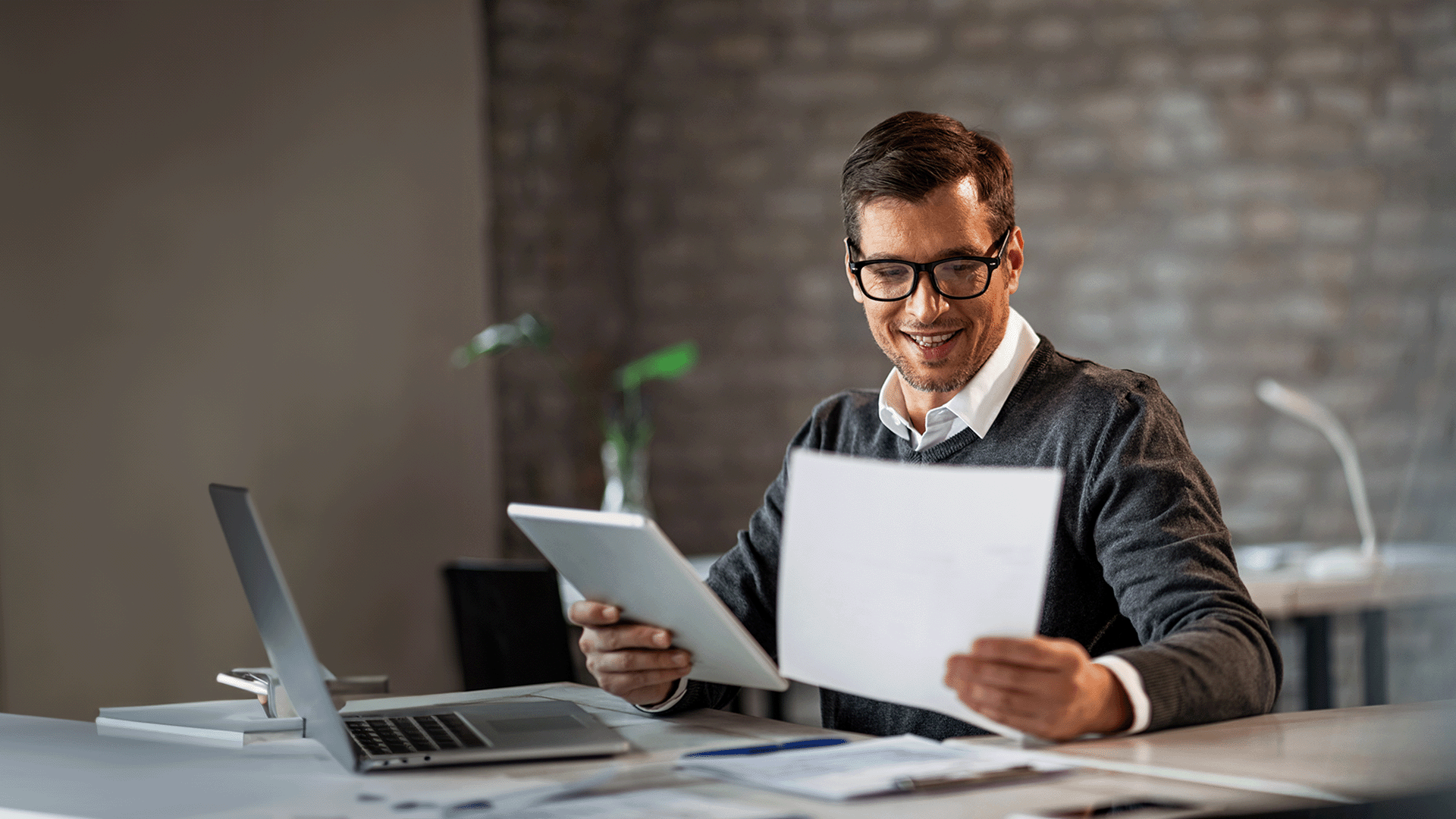 Smiling man at desk doing paperwork
